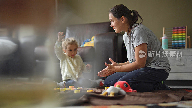妈妈和孩子在家里玩橡皮泥。家庭时间。
