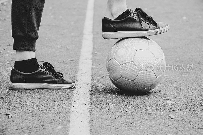 乌克兰，足球场上的女性腿和一个灰色的足球，在院子里踢足球