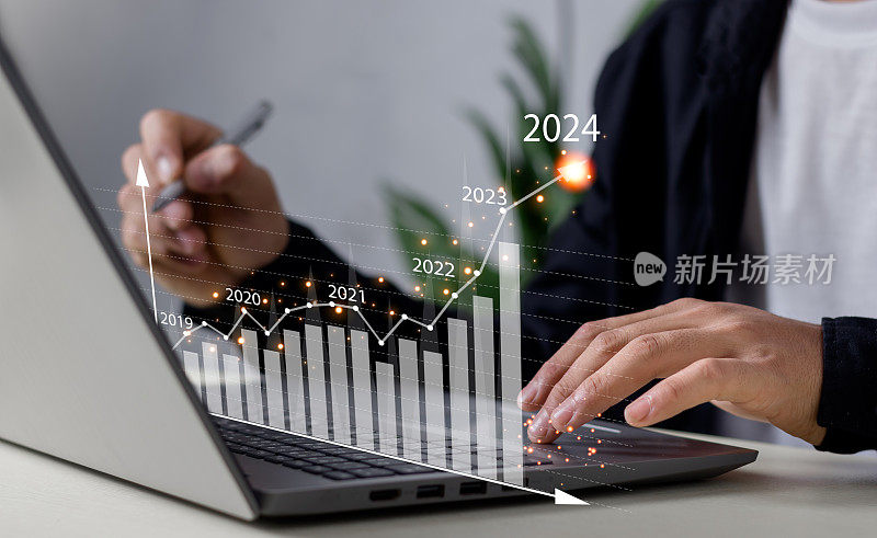 商人在数字笔记本电脑上工作，用数字图形绘制图表，2024年的积极指标，商业计算财务数据，数字营销，金融，交易股票市场的概念。