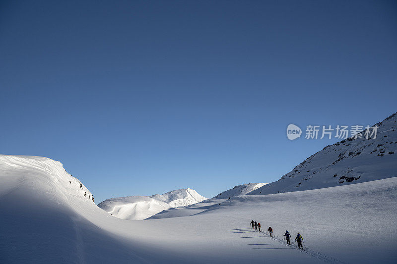 滑雪登山运动员攀登白雪皑皑的山峰