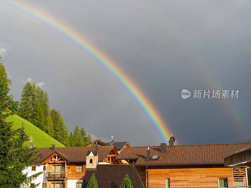 奇妙的双虹在山上。彩虹的鲜艳色彩和云景之间的对比。神奇的大自然