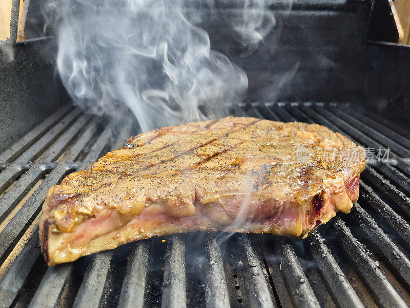 厚切生调味牛肉t骨牛排在木炭烧烤与火焰照片系列