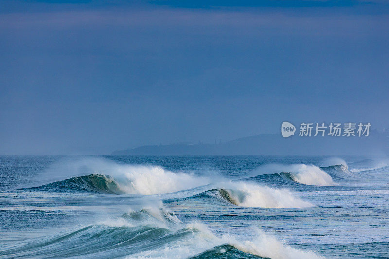 一个波浪在海岸附近破浪而出。