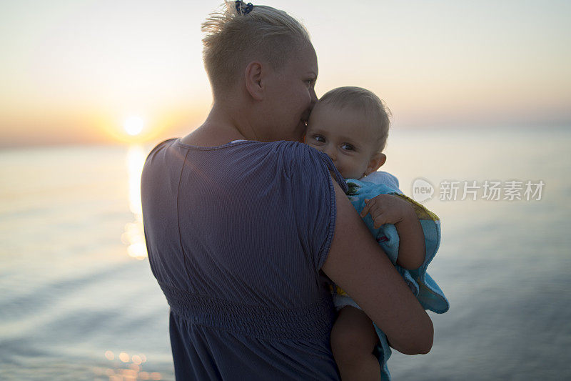 母亲和儿子在海滩上欣赏日落
