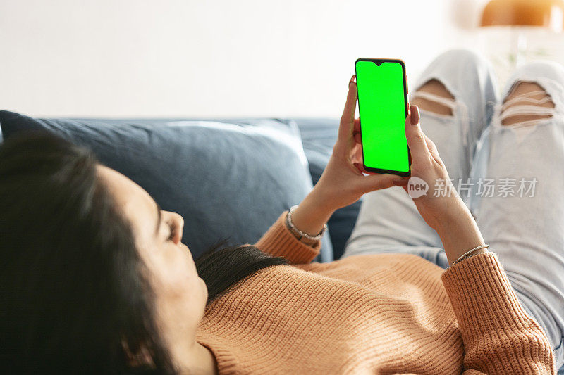 女性手中的绿色屏幕和手机的特写