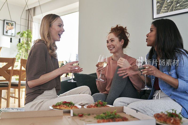 三位白人女性朋友在家里喝酒聊天