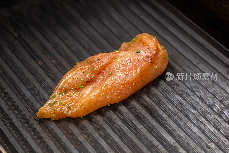 健康的瘦肉鸡胸肉在便携式烧烤架上的热炭上烤着，配上新鲜的西红柿和土豆，这是一顿健康的低脂肪餐