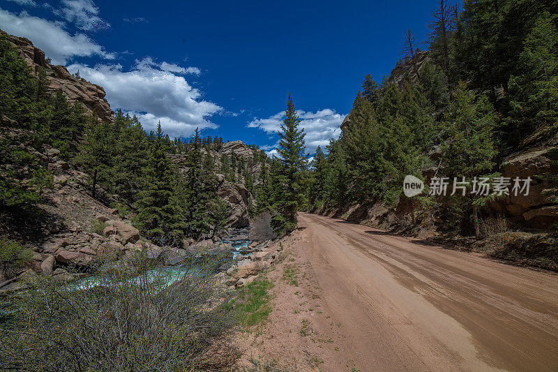 科罗拉多山峡谷泥土路在湍急的小溪旁