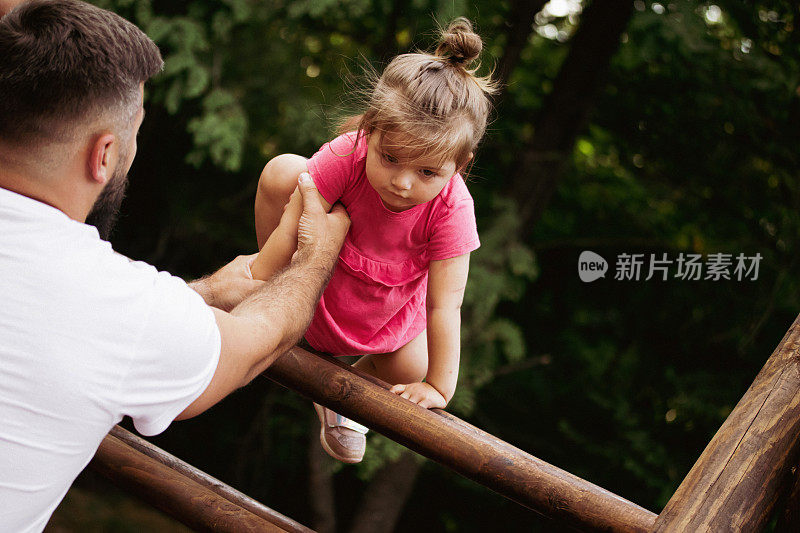 这是爸爸和女儿在操场上玩耍的好日子