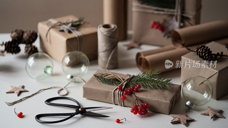 零浪费和环保的圣诞概念。给家人和朋友的圣诞和新年礼物用牛皮纸、绳子和天然植物装饰、树枝、球果、浆果、星星包装。有选择性的重点。