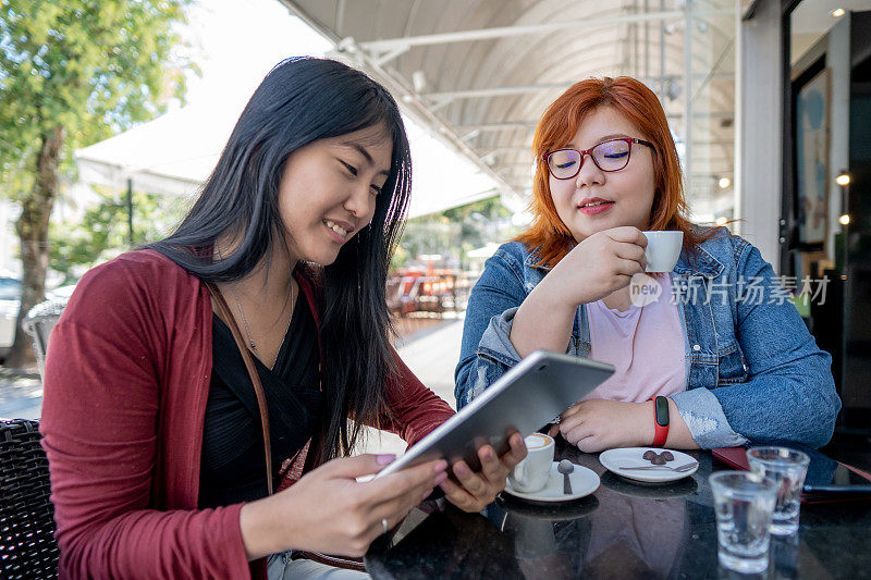 日本女性朋友在咖啡馆使用平板电脑