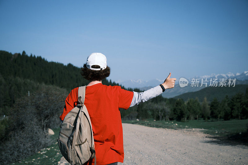 女背包客在山路上搭车