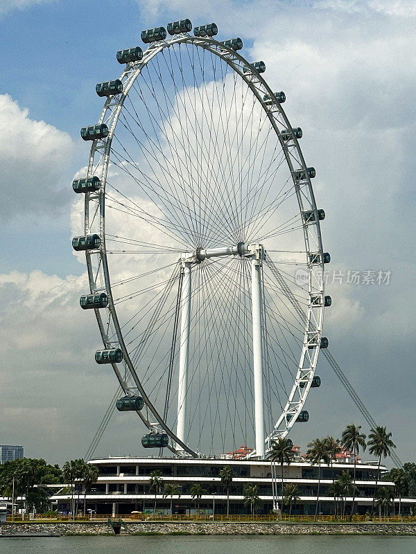 新加坡摩天观景轮的特写图像，以晴朗多云的蓝天为背景，城市滨水区景观，聚焦于前景