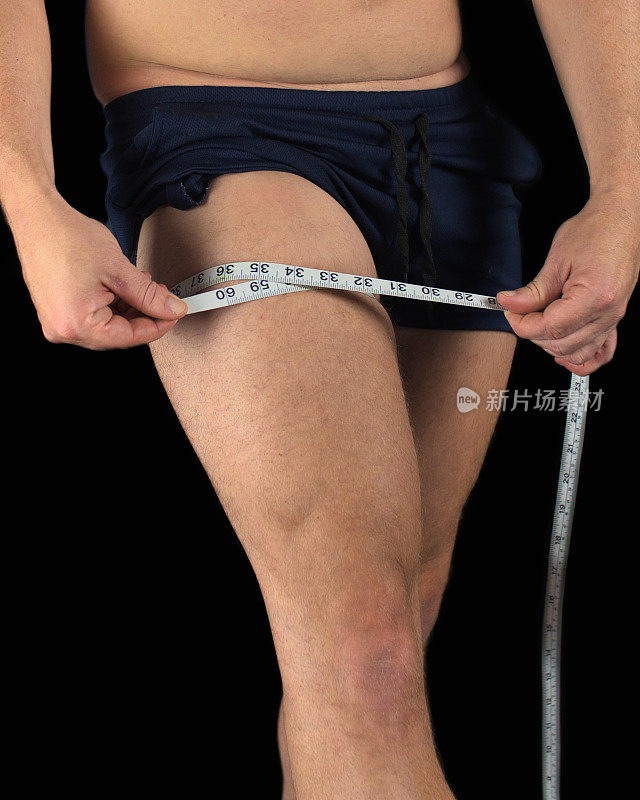 男人用卷尺测量他的腿，看肌肉增加或体重减少的体脂百分比