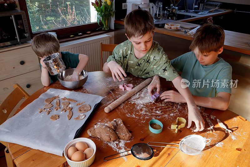 白癜风男孩们在厨房里一起揉面团和做饼干