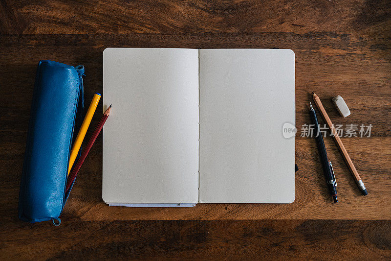 垂直风格的空白速写本在木桌与蜡笔