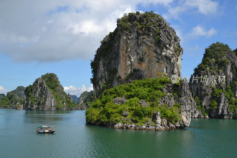 越南下龙湾的石灰岩尖塔或喀斯特岩层与传统渔船