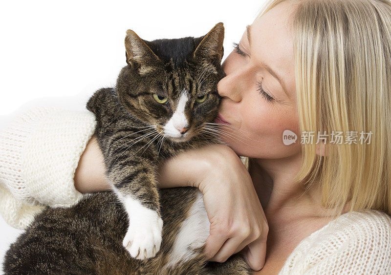 漂亮的年轻女子与家猫拥抱在白色