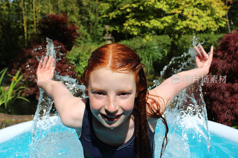 小女孩跳水的画面，在花园的水池中戏水