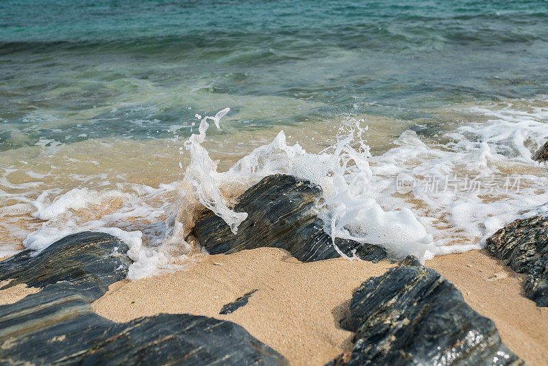 海浪冲击着沙滩上的岩石