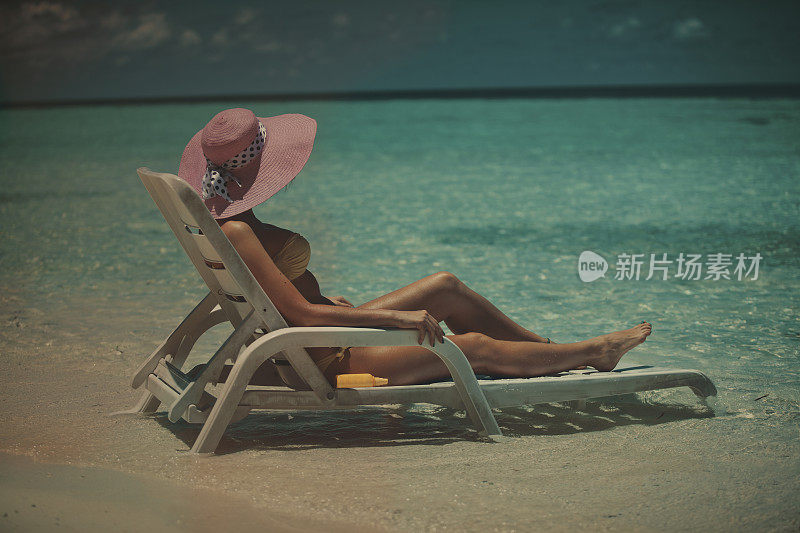 女孩坐在马尔代夫的海边