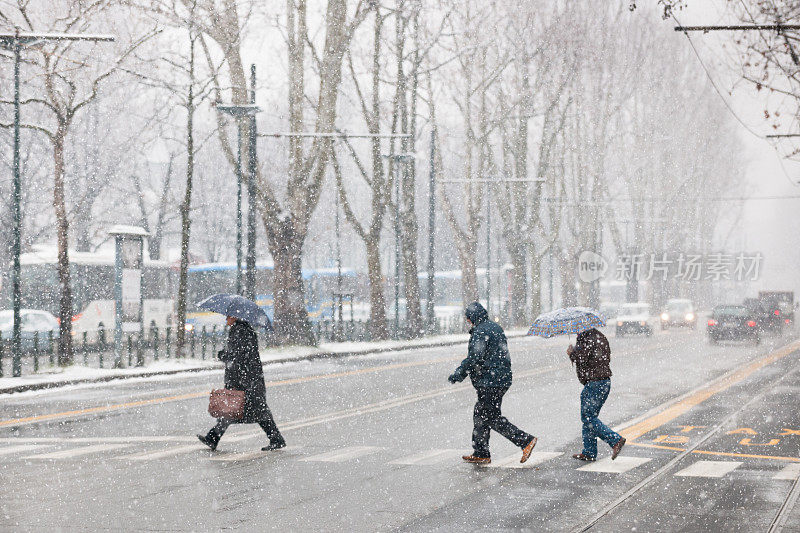 意大利都灵，人们在大雪中穿过街道