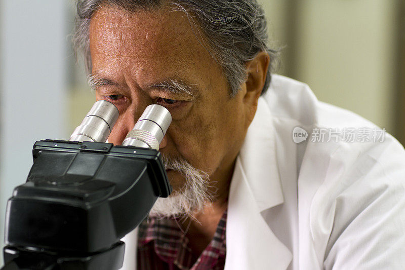 亚洲医师透过显微镜观察