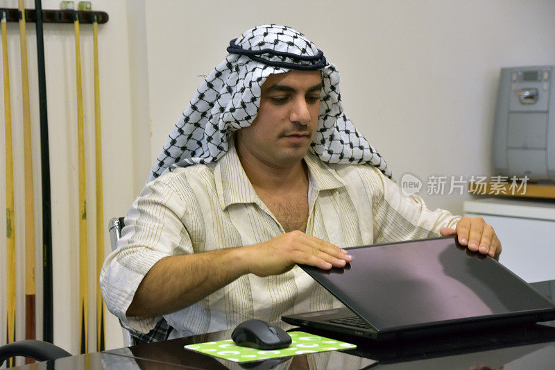 年轻的阿拉伯人在会议室使用笔记本电脑