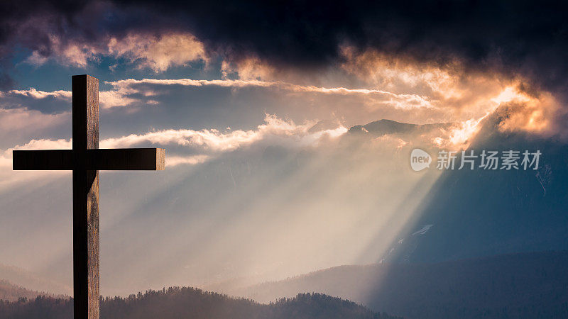 耶稣基督的十字架在一个戏剧性的，多彩的日落