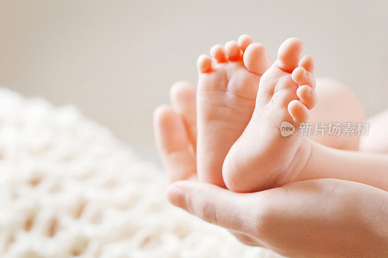 婴儿的脚在妈妈的手里。妈妈和孩子。