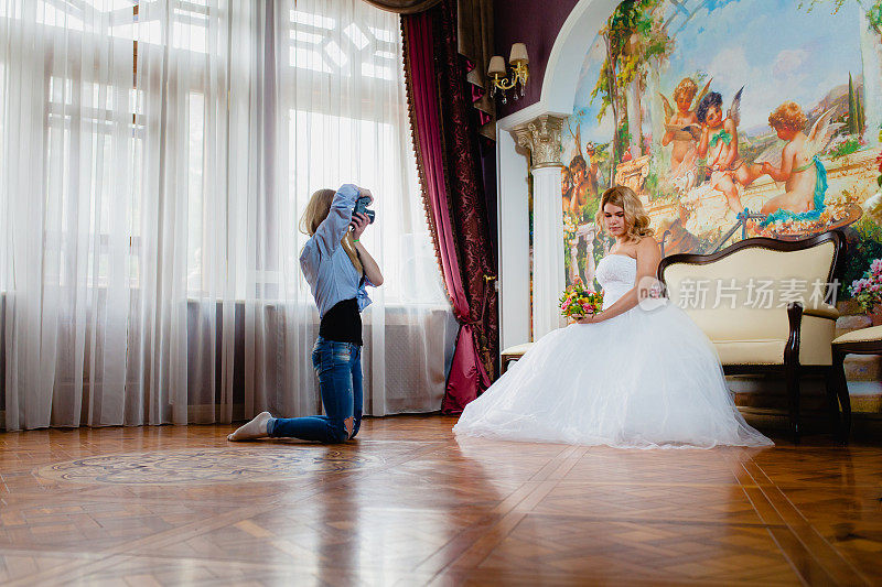 婚礼摄影师正在工作室里给新娘拍照