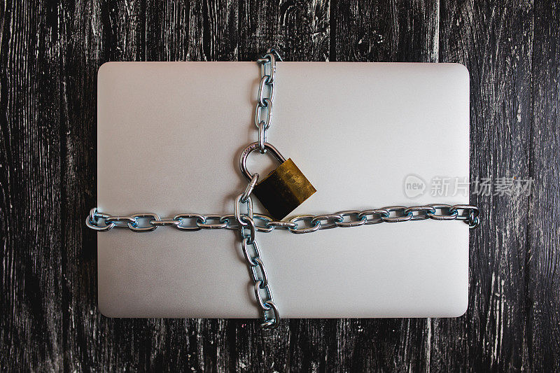 沉重的用挂锁锁着一台孤立的笔记本电脑