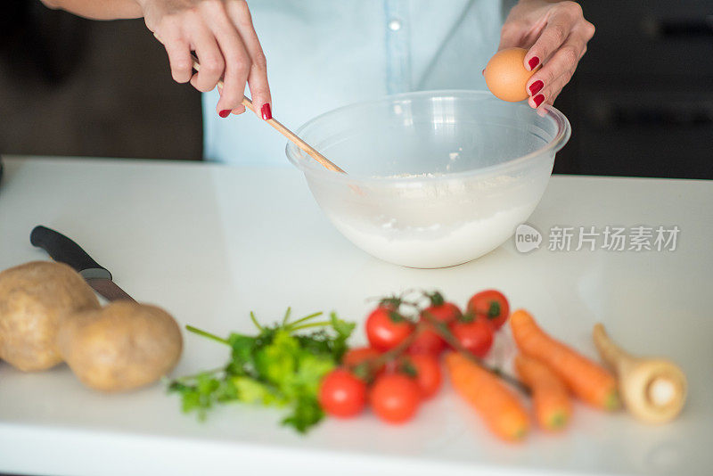 年轻女子在厨房里用蔬菜准备食物