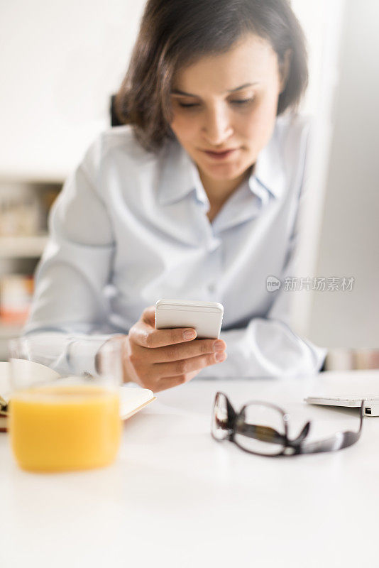 年轻女性在办公室使用智能手机