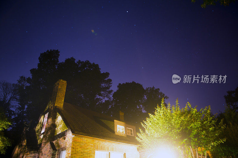 星星在夜晚的天空，在树和房子上面