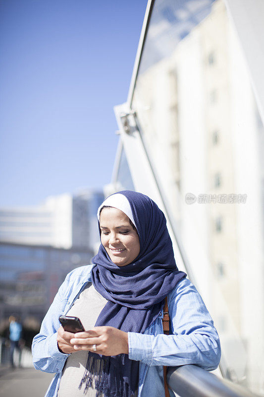 穆斯林妇女用手机和朋友聊天。