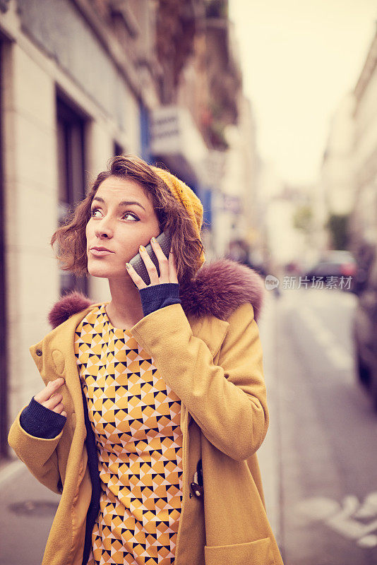 年轻时尚的女人在欧洲的大街上打电话。
