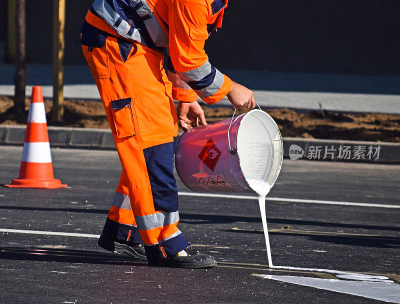 一名男子正在沥青上涂路标