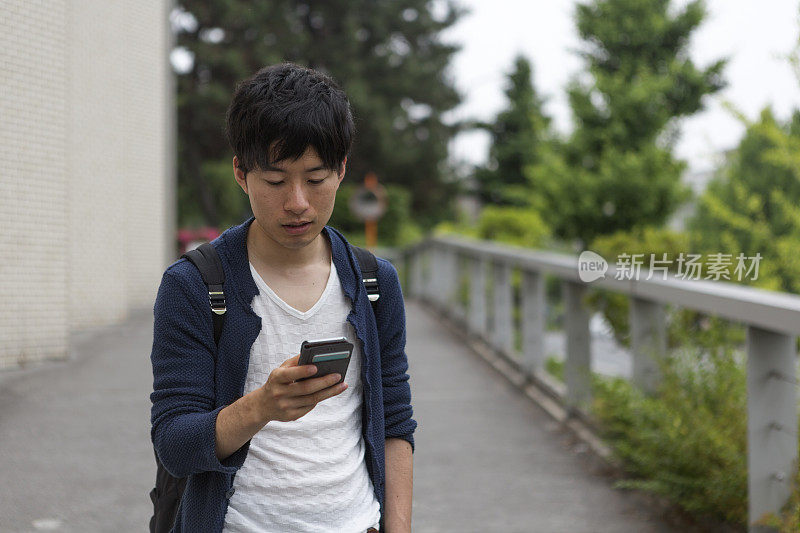 年轻的日本学生在日本京都查看智能手机