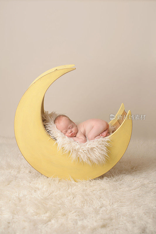 早产儿在木制月亮道具上睡觉