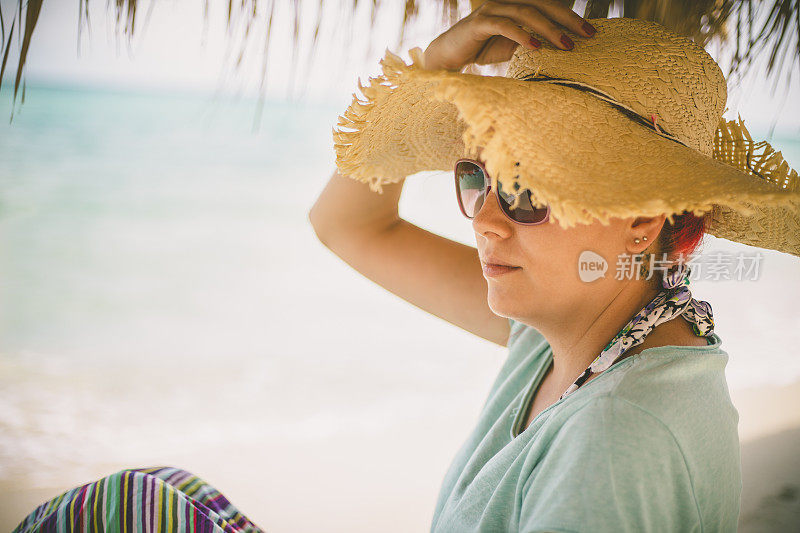 穿着夏装的女人望着天空和大海