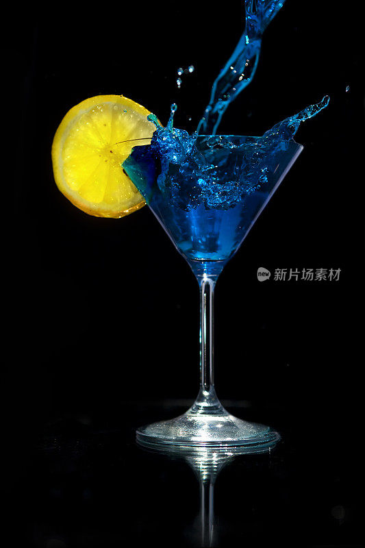 将蓝色马提尼倒入加柠檬的玻璃杯中。