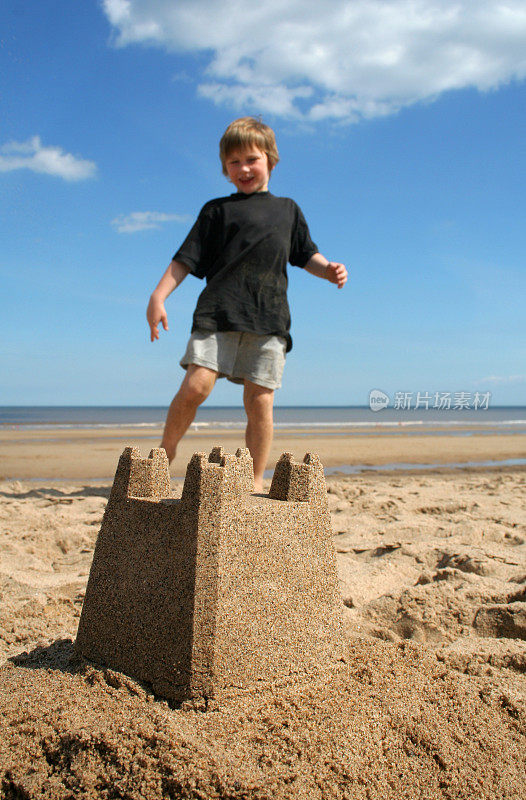 小男孩在沙滩上玩沙堡