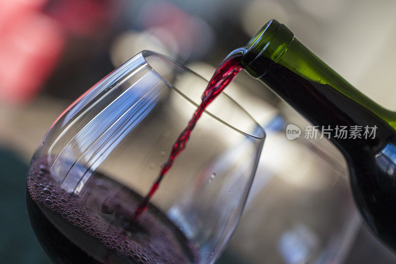 特写红酒被倒入从一个瓶子到玻璃杯。