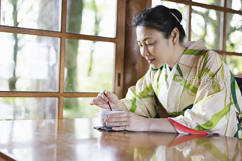 成熟的女人穿着和服，在咖啡馆放松