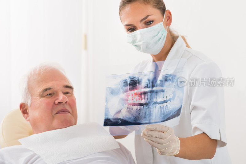 医生给男性病人看牙科x光片