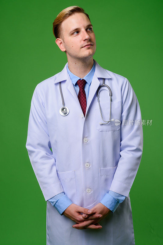 年轻英俊的男医生，金色的头发映衬着绿色的背景