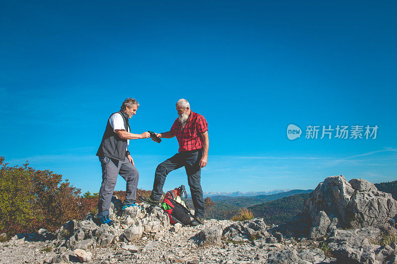 在南朱利安阿尔卑斯山，斯洛文尼亚，欧洲的资深男徒步者正在喝酒