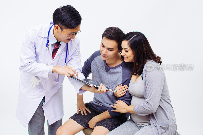 妇科医生或产科医生向一对夫妇展示超声波照片的孕妇和丈夫