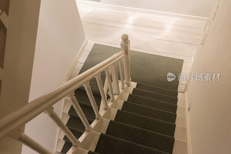 白色木楼梯，铺着绿色地毯